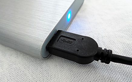 Cable de datos USB enchufado a disco duro externo cromado